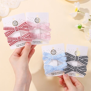 Gros plan de barrettes à cheveux en tissu à carreaux de quatre couleurs sur fond de dentelle