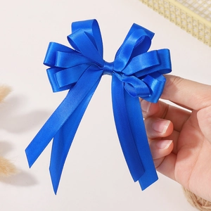Détail d'une pince à cheveux à double nœud en ruban de satin bleu roi de qualité