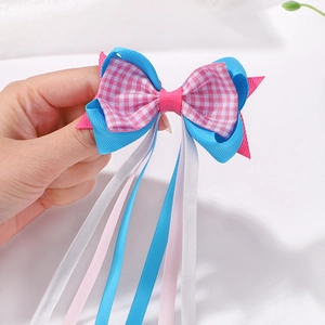 Détail d'un nœud papillon multicouche avec rubans gros-grain bleus et roses à carreaux