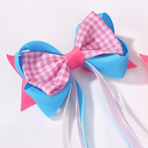 Détail de la pince à cheveux nœud en satin fait main avec rubans roses et bleus
