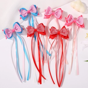 Détail de nœuds papillon pour cheveux avec longs rubans et motifs à carreaux colorés