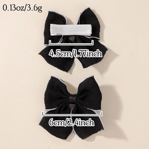 Set of two black fabric bow hair clips with white edge trim and size measurement display