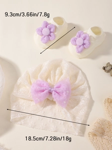 Détail du bonnet en dentelle blanche et chaussettes à fleurs avec étiquettes de taille