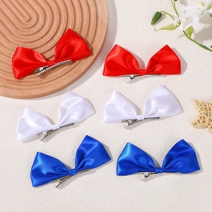 Detailed flat lay of red, white, and navy blue satin ribbon bow hair clips in a 6-piece set