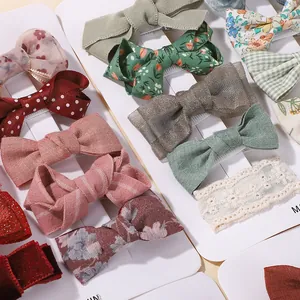 Detailed view of kids hair clip set with assorted floral and bow styles on a white display card