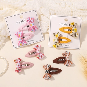 Floral embroidered bow hair clips set for girls featuring pink and yellow fabric patterns