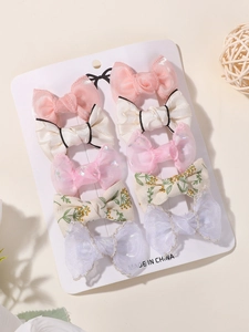 Close-up of 10-piece girls' bow hair clip set with floral and lace textures on display card