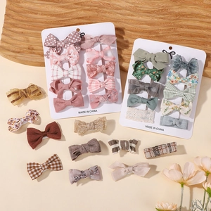 Cute kids hair clip set with floral, plaid, and polka dot bow hairpins on display cards