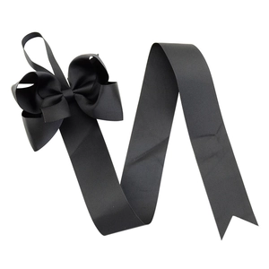 Detail of multi-layered black grosgrain ribbon hair bow with long streaming tails