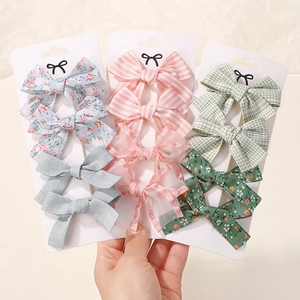Detailed set of 10 bow hair clips in floral, plaid and lace patterns on cards