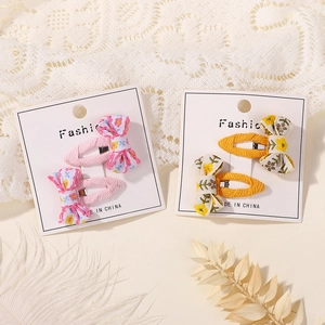 Detail of floral embroidered bow hair clips and fabric hairpins on display card