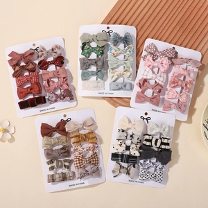 Detailed view of kids cute bow hair clip set with diverse floral and plaid patterns