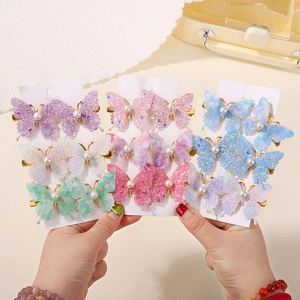 Detail of glitter butterfly hair clips with faux pearls and colorful pastel sequins