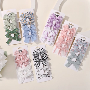 Set of 4 minimalist fabric bow hair clips for girls in assorted floral and plaid patterns