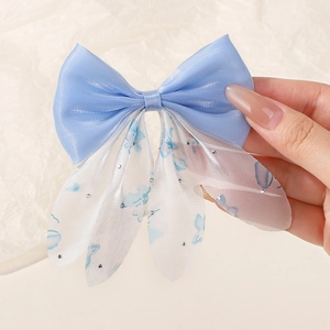 Détail de pince à cheveux papillon bleu clair avec nœud satiné et strass scintillants