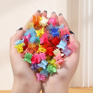 Close-up of colorful butterfly mini hair claws held in hands showing vibrant matte finish