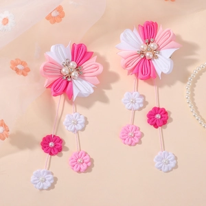 Détail de pinces à cheveux fleurs faites main avec longs glands et perles strass