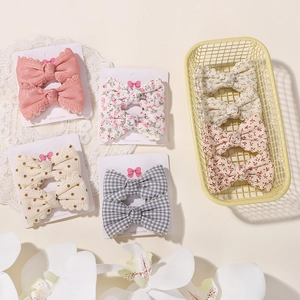 Dettaglio del set di fermagli per capelli rosa con pizzo per bambine su carta