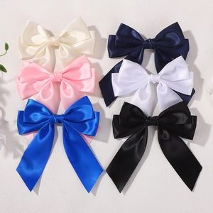 Close-up of high-gloss satin bow hair clips with elegant long ribbons in six colors