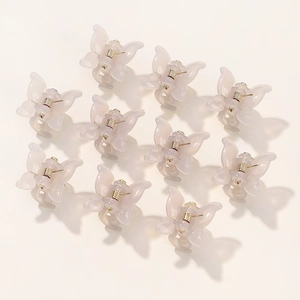 Close-up of 10 mini cream butterfly hair claw clips with translucent matte finish