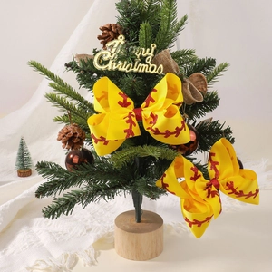 Yellow ribbed bow hair clips with red baseball stitching hanging on a Christmas tree