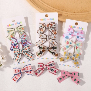 12-piece floral fabric bow hair clip set for girls on a handmade display card