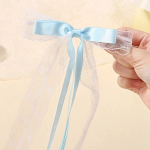 Detalle del lazo azul cielo para el pelo con cintas de encaje floral de gasa