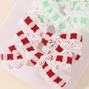 Close-up of handmade lace hair clips with red and green embroidery and wave edges