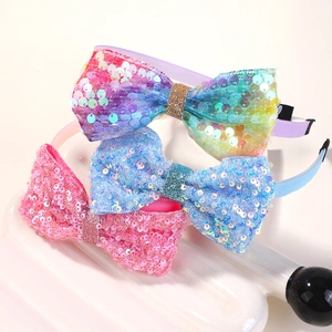 Close-up of glitter sequins texture on rainbow, pink and blue candy bow headbands