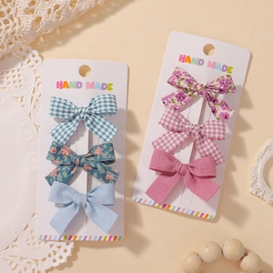 Détail de barrettes à cheveux faites main à fleurs et vichy sur carte de support