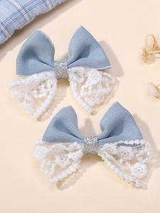 Gros plan détaillé des pinces à cheveux en dentelle bleue avec broderies et accents argent