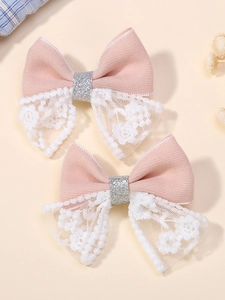 Gros plan de barrettes à cheveux en dentelle rose et blanche pour filles avec paillettes