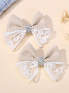 Détail de barrettes à cheveux en dentelle beige avec paillettes argentées