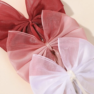 Vue détaillée de barrettes à nœuds en tulle souple en bordeaux, rose et blanc pur