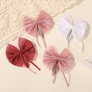 Détail de quatre pinces à cheveux en tulle faites main en blanc, rose et bordeaux pour enfant