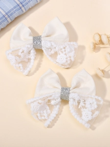 Gros plan de barrettes à cheveux nuds en dentelle crème avec paillettes pour filles
