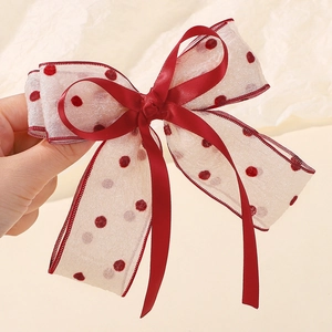 Detail showing the layered red polka dot mesh and satin ribbon on this large bow hair clip