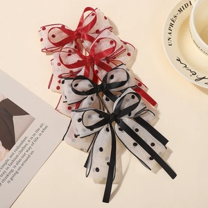 Macro shot of red and black mesh bow hair clips with polka dots and satin ribbon details