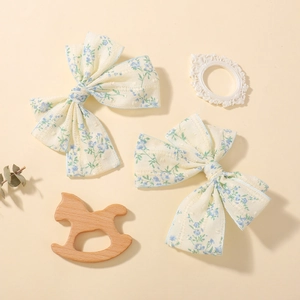 Dettaglio di fermagli per capelli con fiocco floreale, texture a pois e decoro