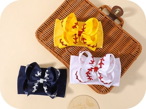 Détail de bandeaux bébé avec nœuds motif baseball dans un panier tressé