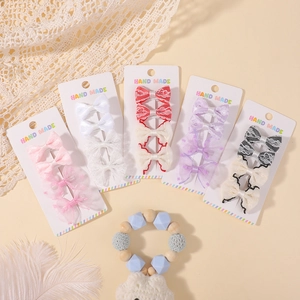 Handmade bow hair clip set for girls with colorful lace and polka dot patterns on card