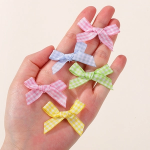 Detailed view of five colorful plaid bow hair clips for girls in pink, blue, green, yellow