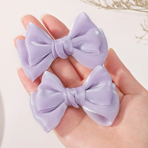 Vue détaillée des barrettes nœuds en satin violet clair avec un fini brillant