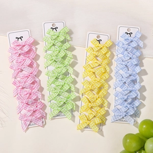 Detailed view of grid pattern bow hair clip set in pink green yellow and blue colors