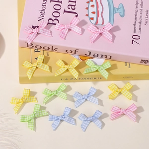 Detailed view of colorful gingham bow hair clips in pink, yellow, green and blue