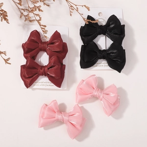 Trois paires de barrettes à nœud brillantes en bordeaux, noir et rose sur cartes de présentation