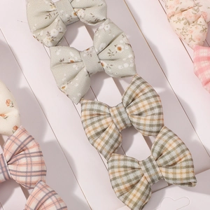 Détail de barrettes à nœuds en tissu avec motifs floraux et à carreaux pour enfants