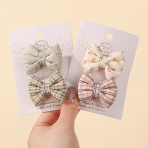 Détail de barrettes à nœuds en coton fleuri et à carreaux sur cartes de présentation