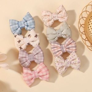Vue détaillée du lot de 7 barrettes à nœuds en tissu aux motifs écossais et fleuris