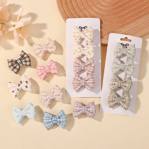 Détail de l'ensemble de barrettes à nœuds fleuris et à carreaux sur carte blanche